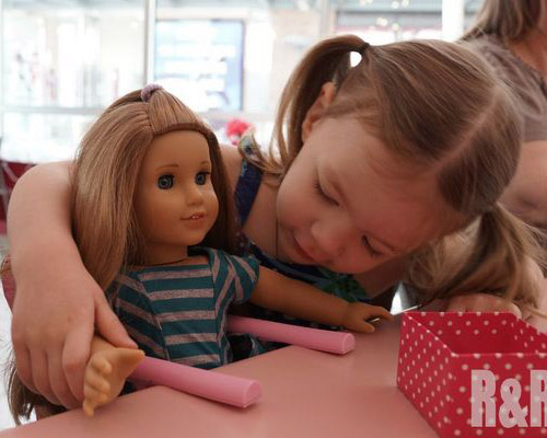 девочка играет куклой